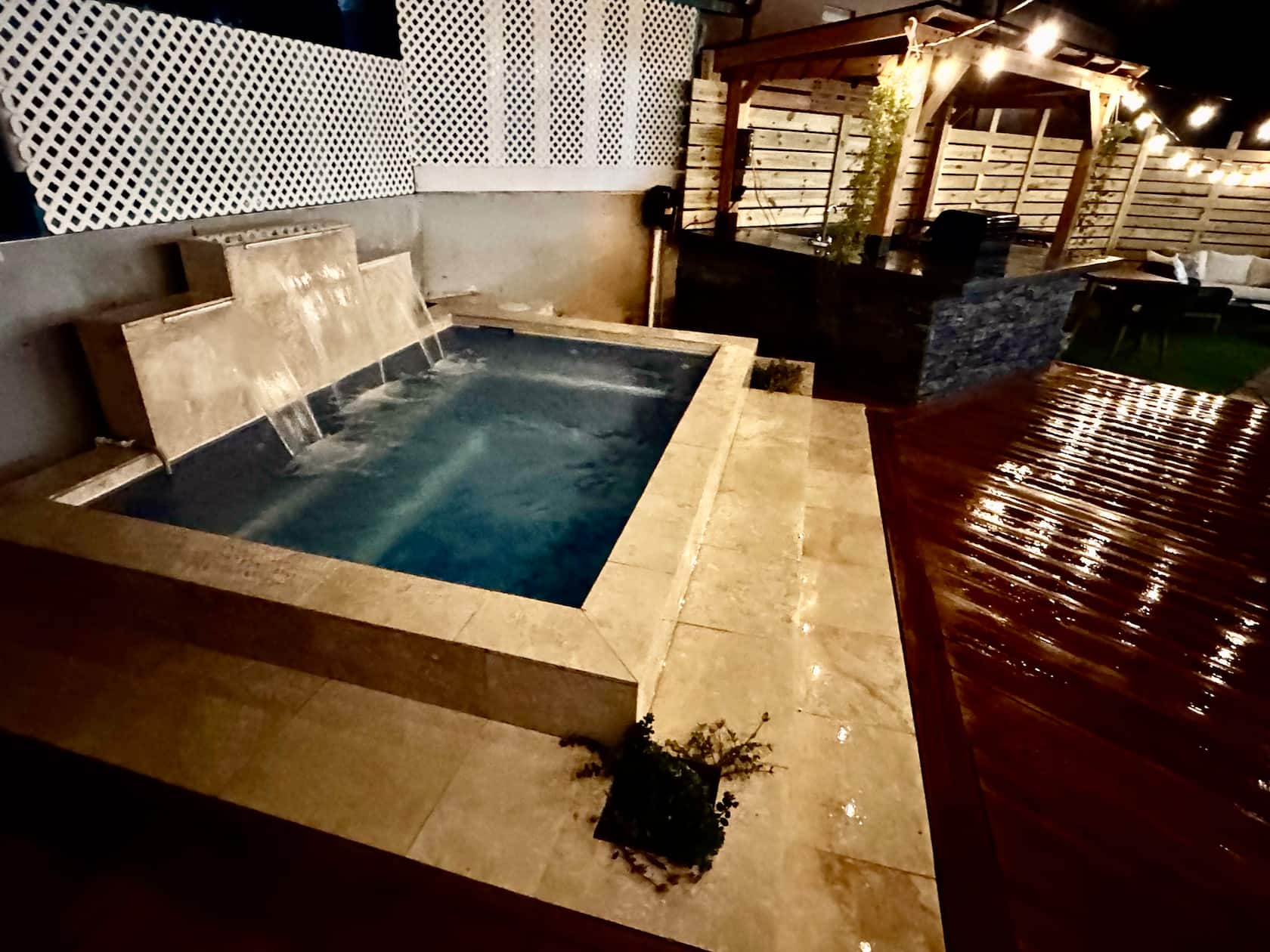 Private pool at night with waterfall feature