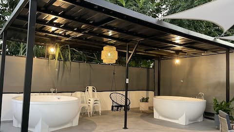 Two private outdoor jacuzzis under a covered patio